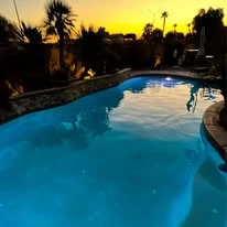 Swimming pool beneath a warm sunset sky